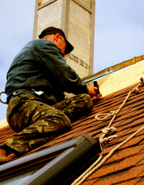 man with harness installing shingles on the roof 1 abita springs la